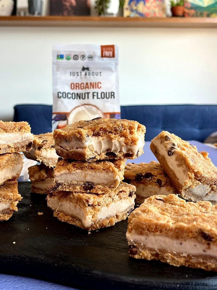 Coconut nice cream bars with crumb coating stacked on a board