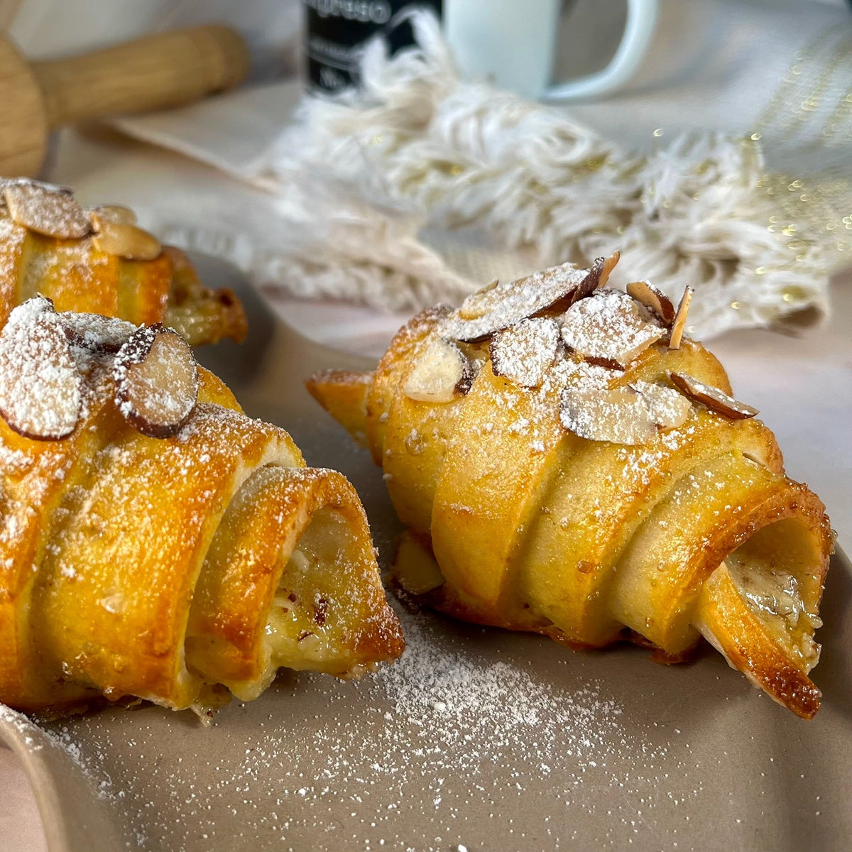 Gluten free almond croissants topped with sliced almonds and powdered sugar